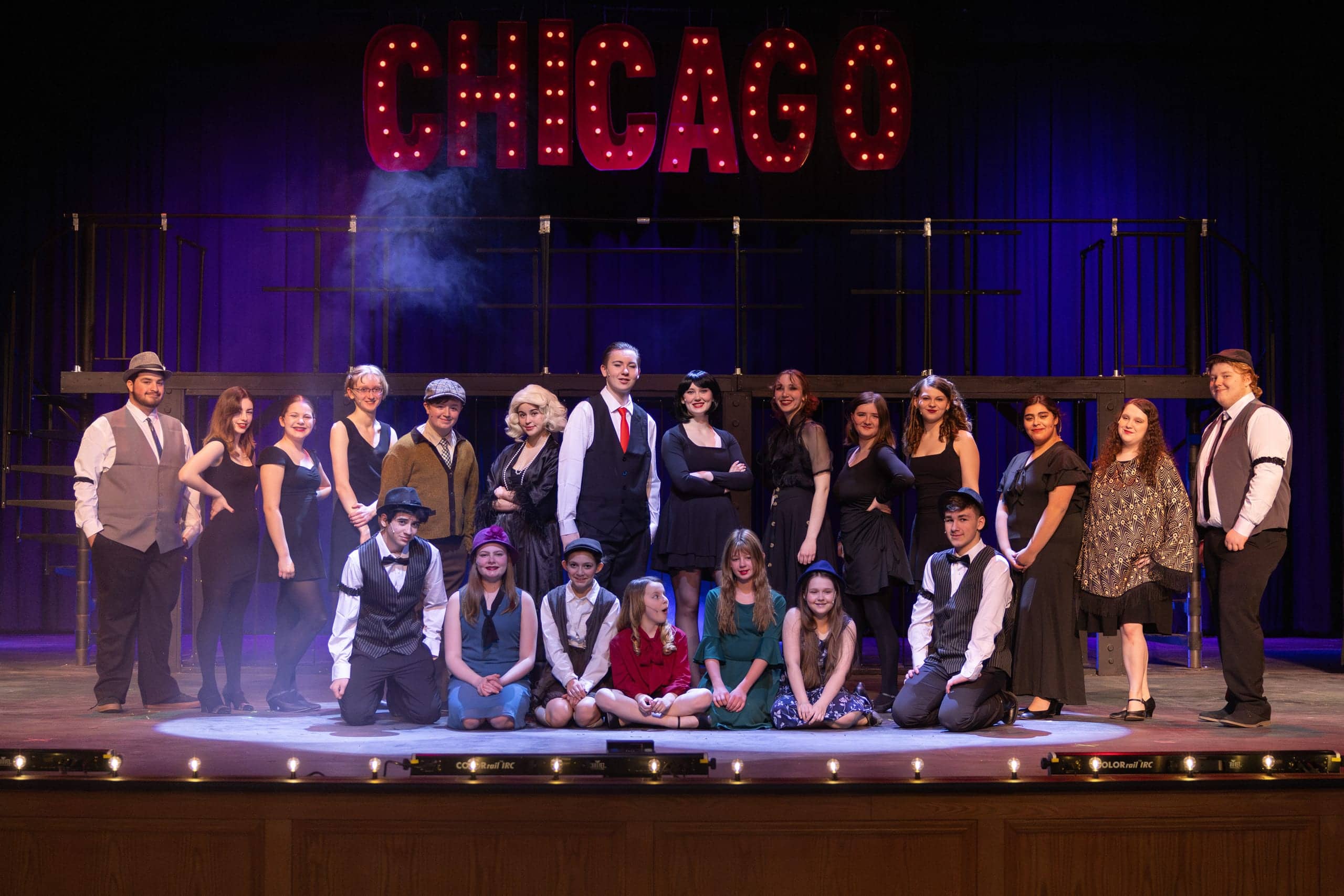Cast of Chicago posed together beneath the marquee in March 2025