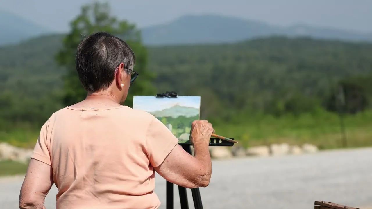 Plein air artist painting a mountain landscape
